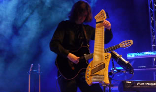 Musiker spielt auf einem (Koyabu-Symmetric-Board) auf einer Bühne mit blauem Licht im Hintergrund.