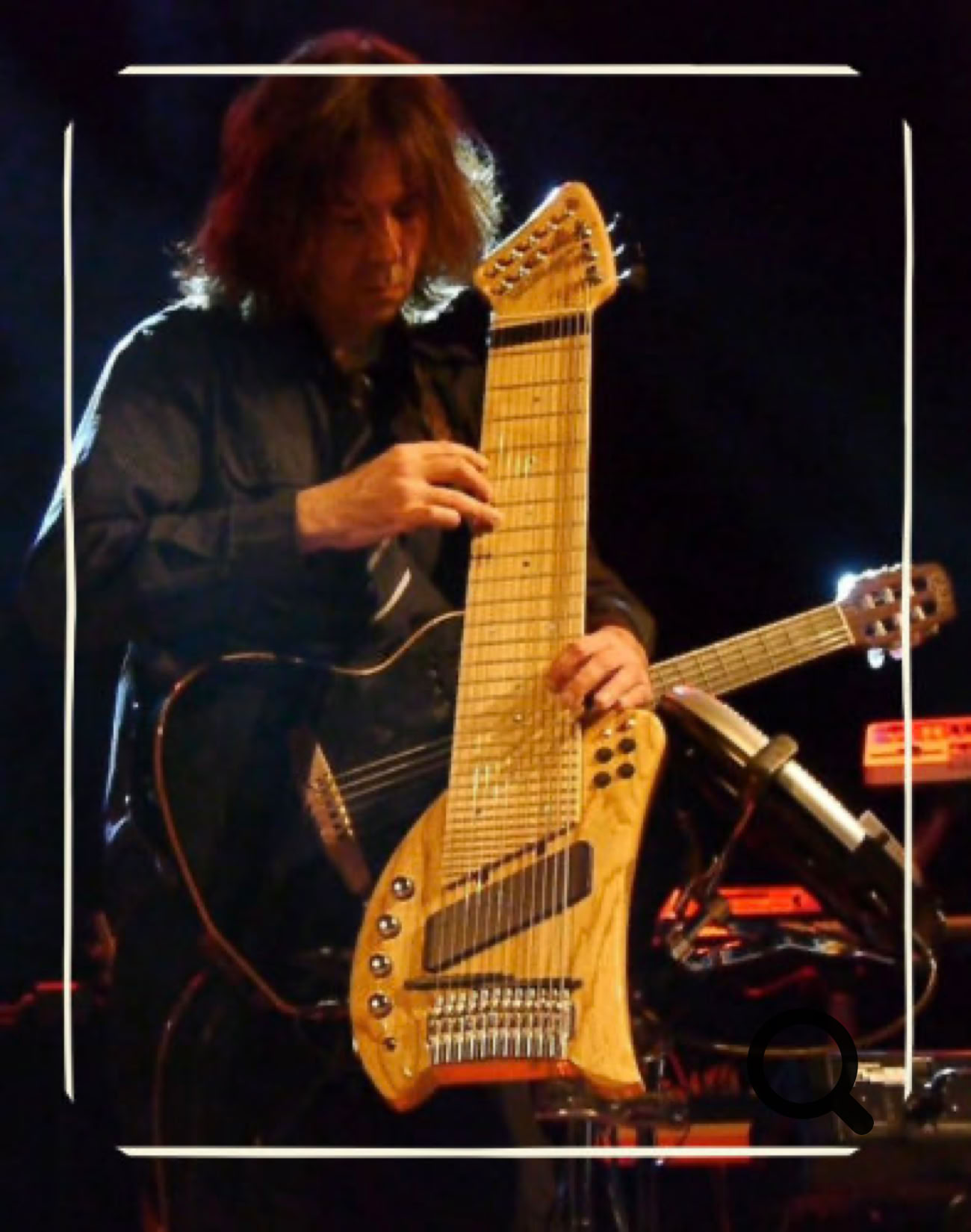 Eine Person spielt ein großes, mehrsaitiges Musikinstrument (Koyabu-Symmetric-Board) auf einer Bühne.